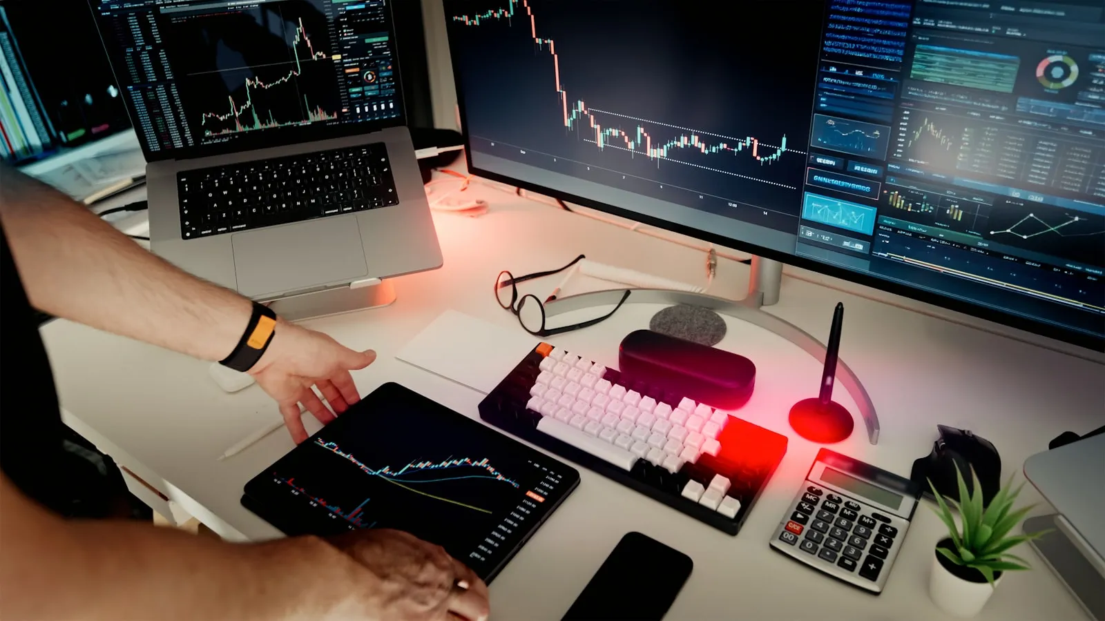 A founder working at a desk with multiple screens and dashboards